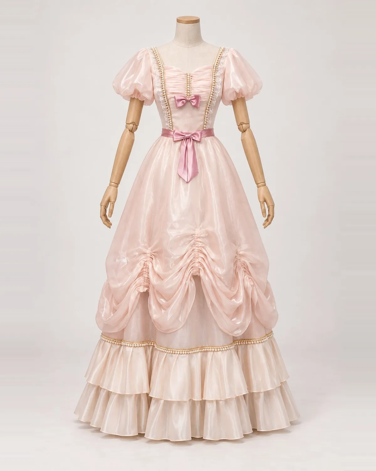 Ninon Rosée — Blush Pink Gown with Bows and Gathered Skirt Swags — shown on a mannequin, front product view